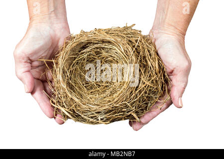 Orizzontale di inquadratura ravvicinata di un vuoto Bird's Nest essendo trattenuto in una donna con le mani in mano. Sfondo bianco. Foto Stock