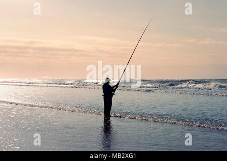 Durban, Sud Africa - 25. Giugno 2017: pescatore la pesca su una spiaggia da sola in Santa Lucia, Hluhluwe National Park, vicino a Durban. Foto Stock
