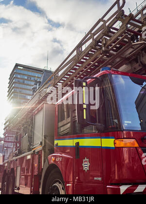 Londra Vigili del Fuoco motore fire apparecchio mostrato in sole brillante contro il cielo blu con sun flare in tutta l'immagine. Foto Stock