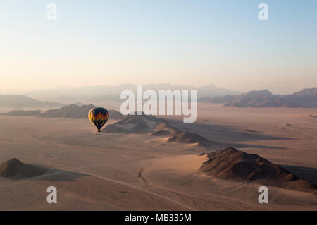 In mongolfiera al di sopra di un arido di pianura e di montagna isolate creste, all'alba, Namib Desert, vista aerea da un secondo palloncino Foto Stock