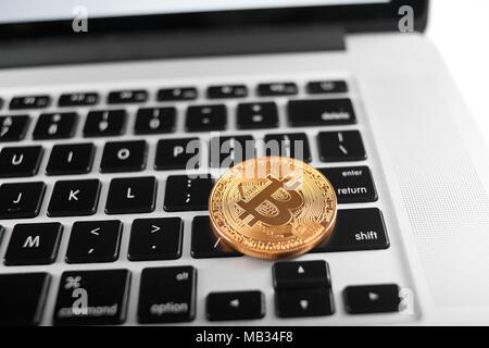 Una golden bitcoin come mondo cryptocurrency principale posto sulla tastiera del notebook. Virtual valuta digitale denaro elettronico blockchain mining exchange innovazione trend futuristico web business finance Foto Stock