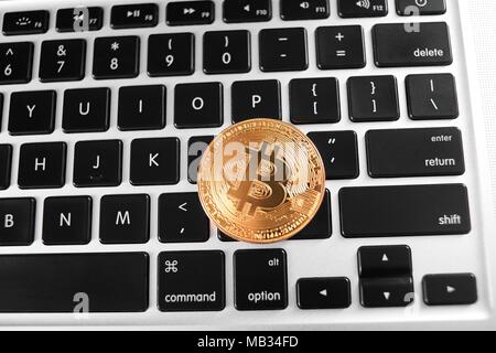 Una golden bitcoin come mondo cryptocurrency principale posto sulla tastiera del notebook. Virtual valuta digitale denaro elettronico blockchain mining exchange innovazione trend futuristico web business finance Foto Stock