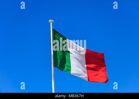 Bandiera dell'Italia. Bandiera italiana su un pennone sventola su un luminoso cielo blu sullo sfondo Foto Stock