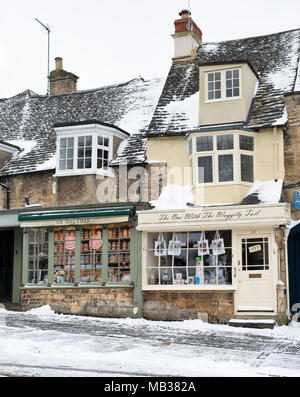 Negozio di dolci e pet shop sulla strada alta nella neve. Burford, Cotswolds, Oxfordshire, Inghilterra Foto Stock