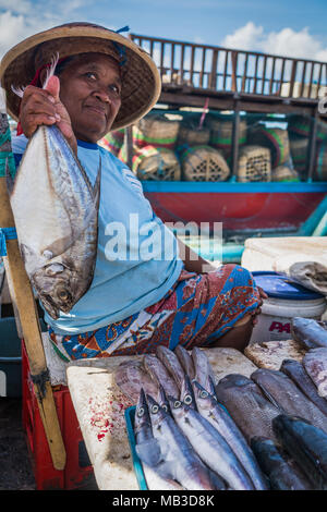 Una donna si siede vendere la sua mercanzia in Jimbaran Mercato del Pesce a Bali Foto Stock