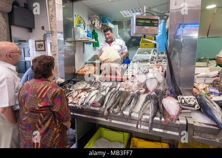 Pescivendolo nel tradizionale indoor/outdoor mercato con bancarelle del fornitore del Mercado de Abastos de Santiago de Santiago de Compostela, Galizia, Spagna Foto Stock