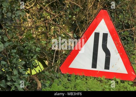 Red triangolo di confine cartello stradale a lato della strada stretta che mostra il lato destro della strada per il traffico Foto Stock