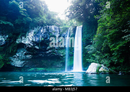 Cascata di Cheonjiyeon lunga esposizione in blu scuro e colori verdi in Seogwipo, Jeju Island, Corea del Sud Foto Stock