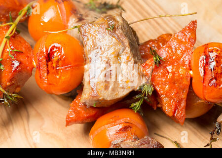 Il cinghiale, il salame chorizo e pomodori ciliegini e timo, cotti su una George Foreman grill. La carne di cinghiale è molto più scura di maiale domestico e del gusto Foto Stock