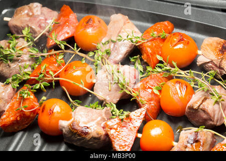 Il cinghiale, il salame chorizo e pomodori ciliegini e timo, cotti su una George Foreman grill. La carne di cinghiale è molto più scura di maiale domestico e del gusto Foto Stock