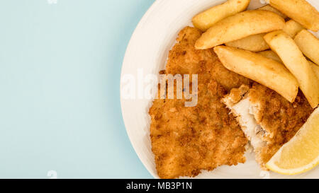 Popolare tradizionale pesce e patatine contro uno sfondo blu Foto Stock