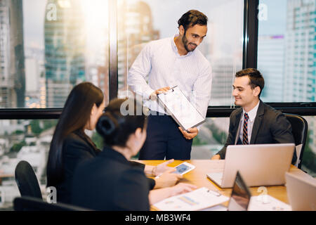 Immagine di business partner per la consulenza presente a discutere di documenti e idee ad una riunione di un gruppo di persone di affari a condividere le loro idee.sorriso e felice busin Foto Stock