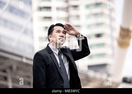 Vista posteriore di uomo di successo imprenditore cercando sul moderno grattacielo mentre in piedi all'aperto, giovane maschio executive director ammira qualcosa su t Foto Stock