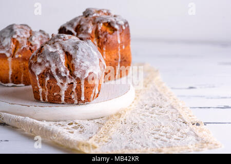 Cotto al forno torta di Pasqua con bianco limone smalto su un tondo in legno bianco bordo, spazio vuoto sulla destra Foto Stock