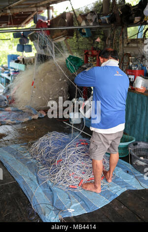 Un pescatore è fissa il suo net at Crab Island, un famoso villaggio di pescatori in Malaysia. Foto Stock