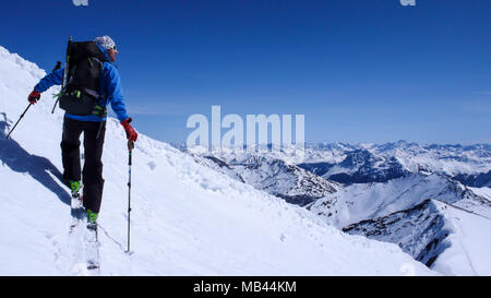 Maschio di backcountry rider andando su un pendio di neve nel backcountry delle Alpi svizzere su un tour di sci in inverno Foto Stock