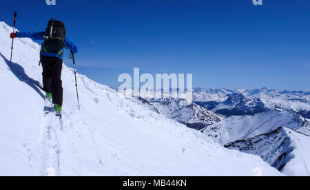 Maschio di backcountry rider andando su un pendio di neve nel backcountry delle Alpi svizzere su un tour di sci in inverno Foto Stock