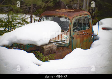 Un vecchio arrugginimento 1951 Ford cinque stelle di carrello, furono sepolti nella neve in una zona boschiva dietro un fienile in Noxon, Montana. Questa foto è stata scattata con un antico Petz Foto Stock