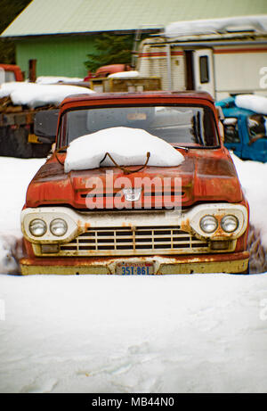 Un vecchio, rosso 1960 Ford F-100 pickup truck, della neve, sul lato di un fienile in Noxon, Montana. Questa foto è stata scattata con un antico Petzval lente e Foto Stock
