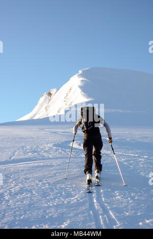 Maschio di backcountry rider escursionismo in remoto a un summit nelle Alpi su una bella giornata invernale Foto Stock