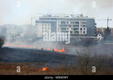 Un incendio di prati nei pressi di un grande complesso residenziale a Lublino. Foto Stock