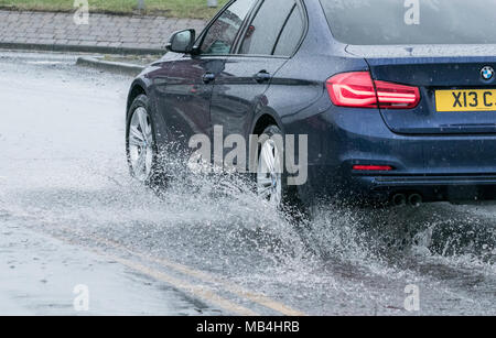 Southport, Merseyside. Il 7 aprile 2018. Regno Unito Meteo. Aprile docce rain verso il basso provocando allagamenti localizzati a costruire lungo la principale strada costiera tra il Southport e Liverpool. Auto e furgoni schizzato il loro modo attraverso le enormi pozzanghere come le code di traffico costruito dietro. Credito: Cernan Elias/Alamy Live News Foto Stock