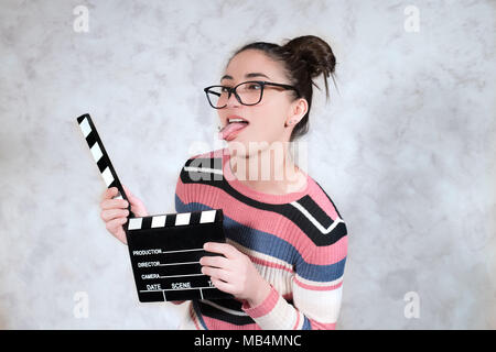 Donna giovane attrice commedia divertente faccia grimace espressione bocca aperta con filmato battaglio board Foto Stock