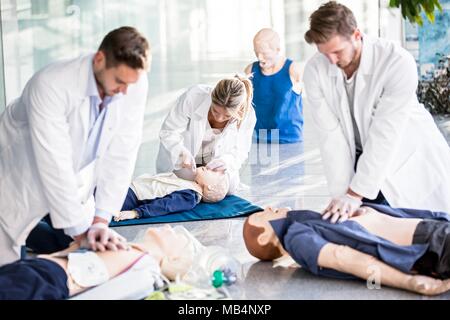 Modello rilasciato. I medici impresa formazione CPR su fantocci. Foto Stock