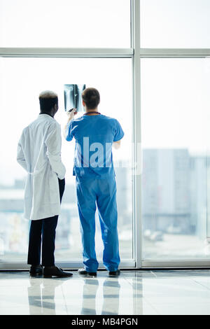 Indietro di due medici controllo raggi X su un ufficio moderno sfondo Foto Stock