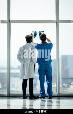 Indietro di due medici controllo raggi X su un ufficio moderno sfondo Foto Stock