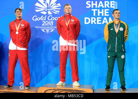 L'Inghilterra del James Wilby (argento), Adam torbosi (oro) e del Sudafrica Cameron van Der Burgh (bronzo) con le loro medaglie dopo gli Uomini 100m Rana finale al Gold Coast centro acquatico durante il giorno tre del 2018 Giochi del Commonwealth in Gold Coast, Australia. Foto Stock