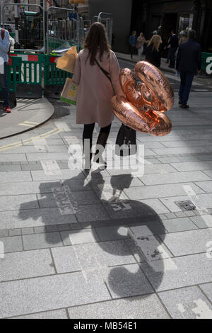 Una signora porta due trentesimo compleanno palloncini lungo Bond Street nel centro di Londra, il 6 aprile 2018, a Londra, in Inghilterra. Foto Stock