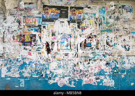 Parete dipinta rivestiti con strati di vecchi strappati poster e volantini. Foto Stock