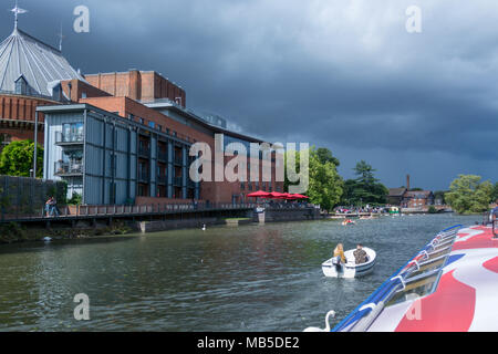 Stratford upon Avon warwickshire England Regno Unito Aprile 2018 barche passando davanti al Royal Shakespeare Theatre con nuvole temporalesche in backgr Foto Stock