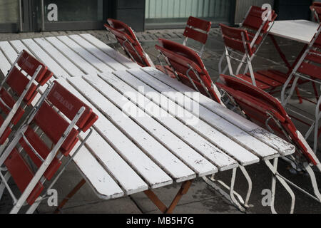 Svuotare caffè Terrazza tavoli sedie socchiusa Legno Bagnato parete molla fuori stagione. Foto Stock