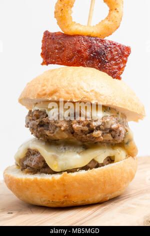 Un doppio cinghiale hamburger fatto da un cinghiale ripreso in Toscana Italia, dotate di cambozola formaggio e guarnita con il salame chorizo e profondo fritto onion r Foto Stock