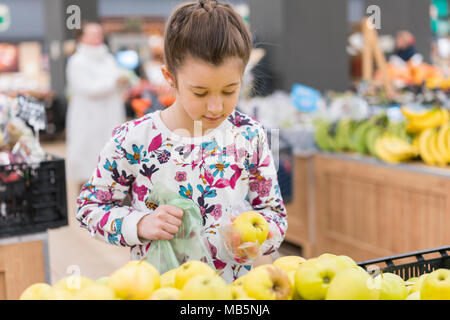 Bambina scelta di mele mature in un negozio di generi alimentari o supermercati. Foto Stock