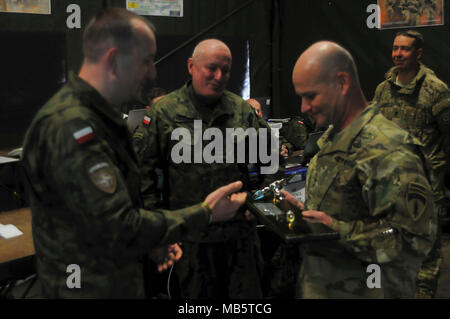 Lt. Gen. Christopher Cavoli, Esercito degli Stati Uniti in Europa (USAREUR) commander, riceve un dono di apprezzamento da Briga. Gen. Jarosław Gromadziński, xv meccanizzata di comandante di brigata, per visitare la rafforzata presenza di avanzamento gruppo di combattimento della Polonia e xv brigata meccanizzata in Orzysz, Polonia, 22 febbraio, 2018. Il gruppo di combattimento della Polonia è un luogo unico e multinazionali del Battle Group è composto da Stati Uniti, Regno Unito, croato e soldati rumeni che servono con il polacco della XV Brigata meccanizzata come una forza di dissuasione nel nord-est della Polonia a sostegno della NATO in avanti rafforzata presenza. Foto Stock