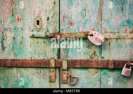 Porta bloccata. Chiuso il vecchio arrugginito lucchetti su un distressed porta di legno, primo piano Foto Stock