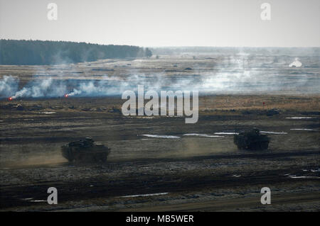 Stati Uniti Stryker veicoli tattici in anticipo tramite l'obiettivo durante la fase di esercizio Puma Live esercitazione antincendio vicino Bemowo Piskie Area Formazione, Polonia nel febbraio 23, 2018. Gruppo di combattimento della Polonia è un luogo unico e multinazionali del Battle Group, composta di Stati Uniti, Regno Unito, croato e soldati rumeni che servono con il polacco della XV Brigata meccanizzata come una forza di dissuasione nel nord-est della Polonia a sostegno della NATO in avanti rafforzata presenza. Foto Stock