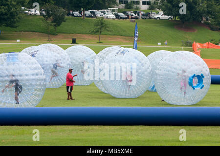 Molti bambini stessi push intorno a grandi zorbs su un campo in erba al terzo annuale di Atlanta Gelato Festival il 27 luglio 2013 ad Atlanta, GA. Foto Stock