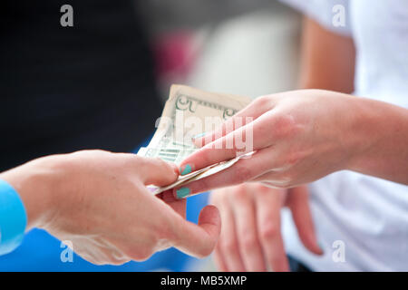 Primo piano di due le mani delle donne lo scambio di denaro presso un fornitore stand annuale di Atlanta Gelato Festival il 27 luglio 2013 ad Atlanta, GA. Foto Stock