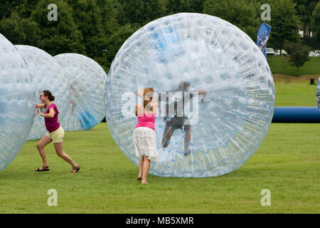 Spingere le donne giovani intorno alla laminazione zorbs al terzo annuale di Atlanta Gelato Festival a Piedmont Park, il 27 luglio 2013 ad Atlanta, GA. Foto Stock