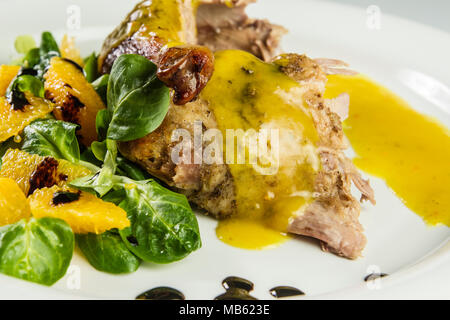 Gambe d'anatra con salsa di arancio e la valeriana con insalata di arance e aceto. Foto Stock