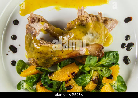 Gambe d'anatra con salsa di arancio e la valeriana con insalata di arance e aceto. Foto Stock