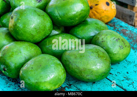 Pila di green mango sul turchese tabella sulla strada stallo in Guatemala, America Centrale Foto Stock