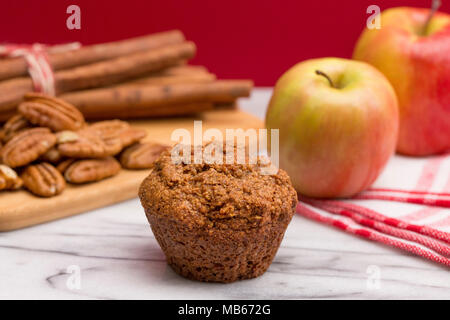 Mela Cannella Muffin alle noci pecan su un Apple Sfondo rosso Foto Stock