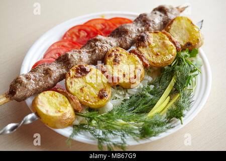 Barbecue grigliate Lula Kebab con carne macinata, patate, verdure fresche e verdi Foto Stock