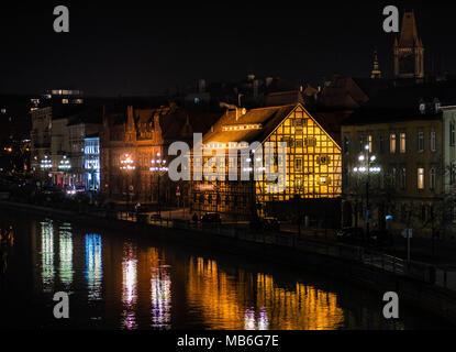 Illuminazione di una casa in legno e muratura presso le rive del fiume Brda a Bydgoszcz (Polonia) Foto Stock