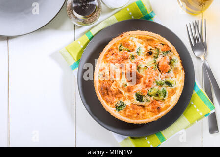 Classic salmone e broccoli quiche fatta da pasta frolla con cime di broccoli e salmone affumicato in un cremoso intervallo libero crema di uovo Foto Stock